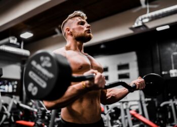 Sporter voert een bicep curl uit met een halter