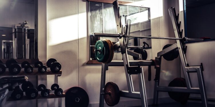 Sporter voert een squat uit met een halterstang