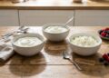 Schaaltjes magere kwark, skyr en hüttenkäse naast elkaar op een lichte keukentafel