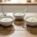 Schaaltjes magere kwark, skyr en hüttenkäse naast elkaar op een lichte keukentafel